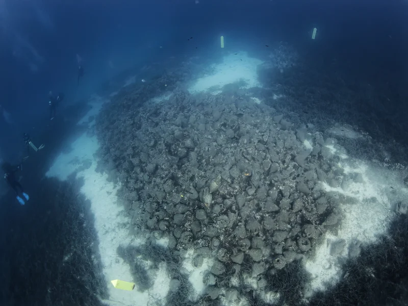 Underwater view of ancient Greek amphorae scattered across the seabed at the Peristera shipwreck archaeological site